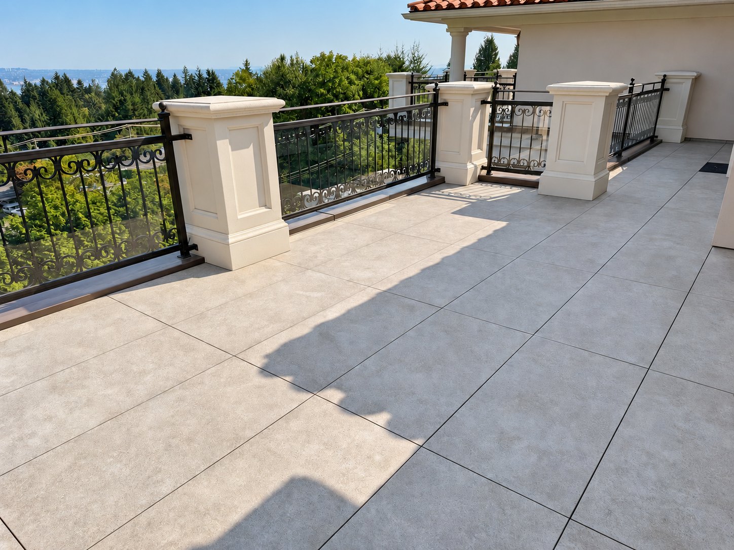 Renovated West Vancouver deck with large-format pavers and existing black railings
